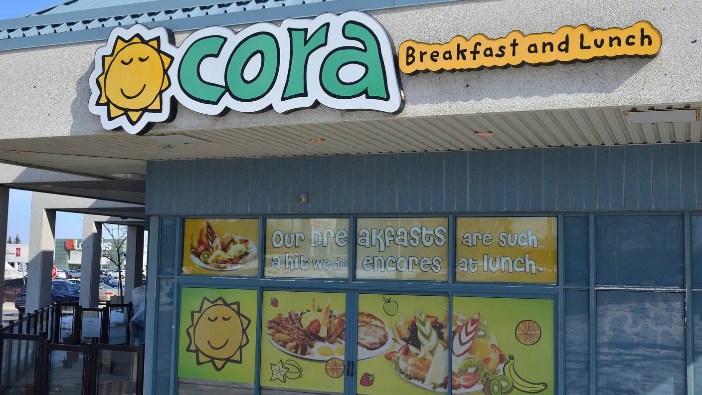 The Cora breakfast and lunch storefront with its sun logo