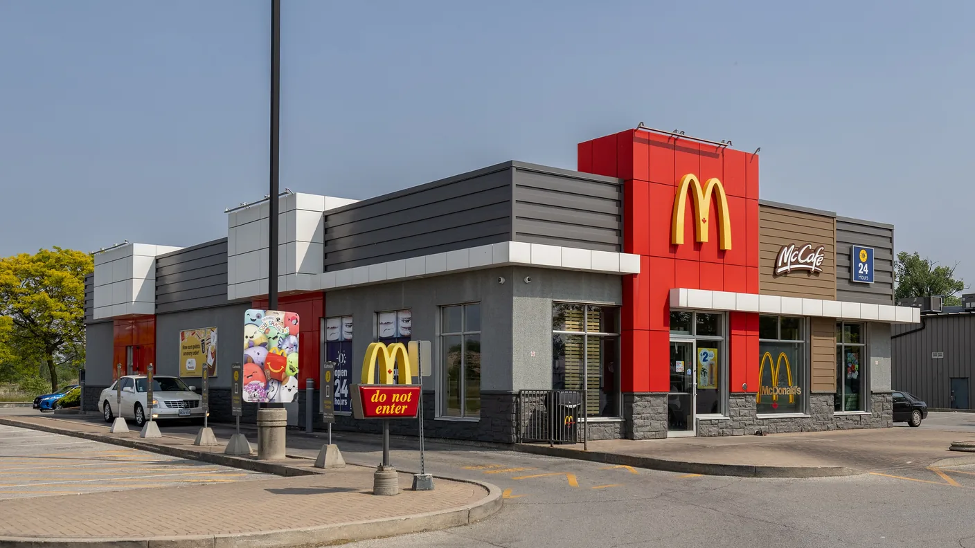 A McDonald's restaurant with the golden arches on the corner